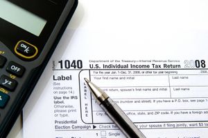 A 1040 form with a pen and calculator beside it