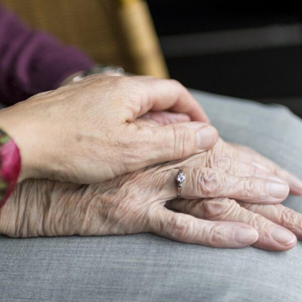 elderly couple holding hands