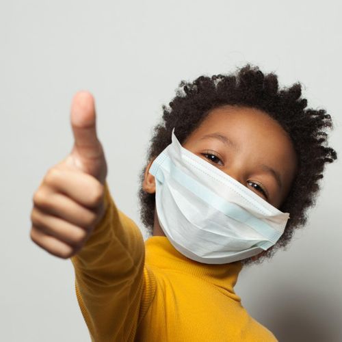 kid in mask giving thumbs up