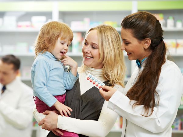 Image of a pharmacist giving pills to a child
