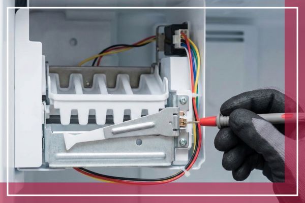 Gloved hands testing ice maker electrical components with a multimeter.