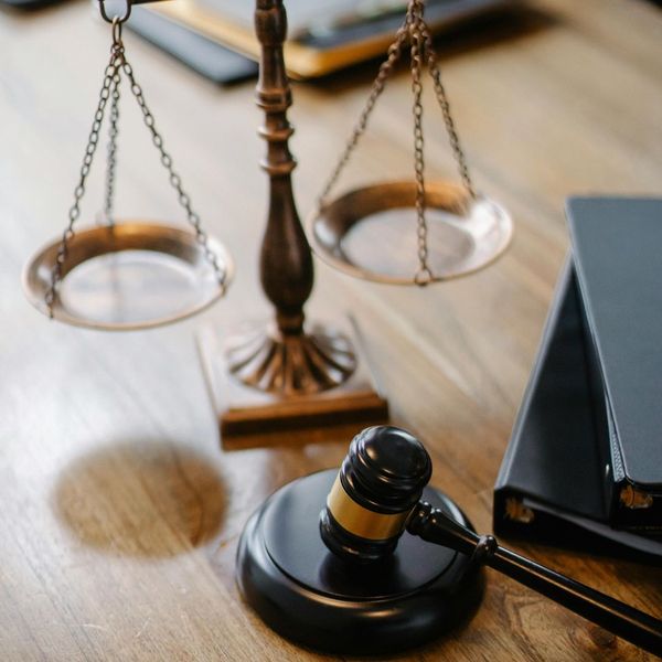 A close-up of a gavel and a set of scales of justice on a wooden desk, symbolizing legal and ethical frameworks. A close-up of a gavel and a set of scales of justice on a wooden desk, symbolizing legal and ethical frameworks.