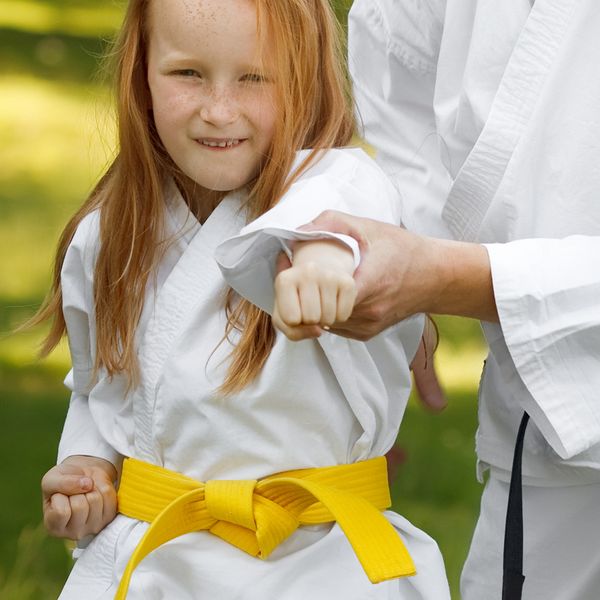 Image of a little girl being shown how to punch