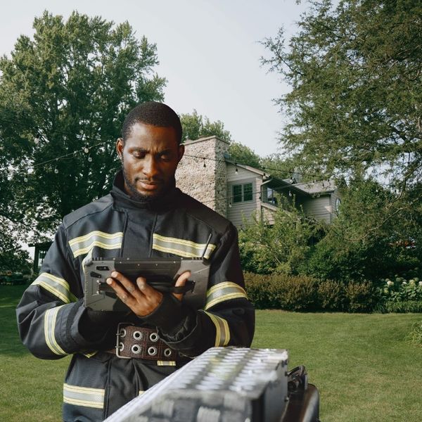 a firefighter using an ipad in a backyard