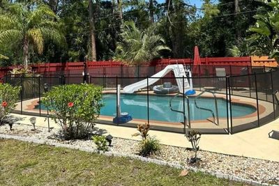 fence around an in-ground pool with a slide