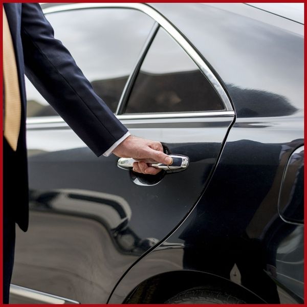 A chauffeur opening the limo door for concertgoers. blog 4.jpg