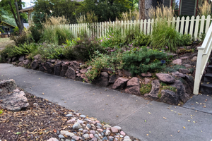 the front of a home with plantings and rock formations