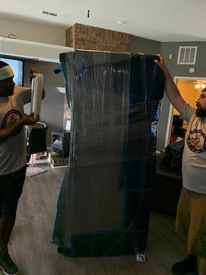 Men wrapping furniture to move safely