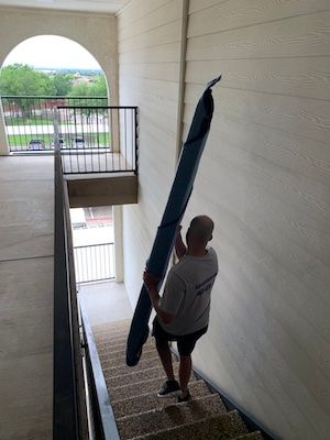 Man moving large object down stairs