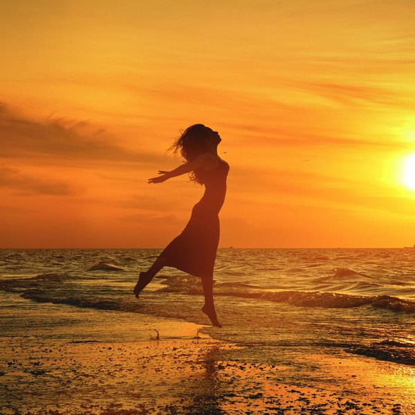 woman dancing on the beach at sunset woman dancing on the beach at sunset