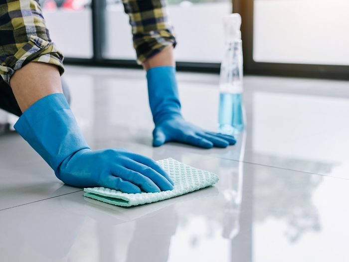 A person scrubbing a tile floor
