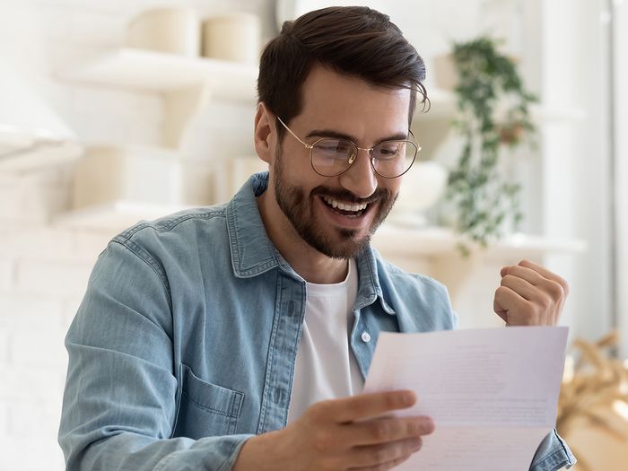 A man looking happily at paperwork