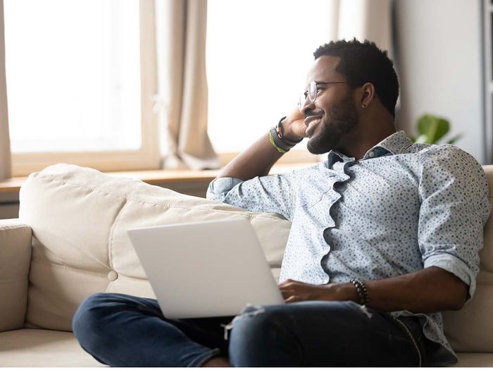 confident man on couch with laptop