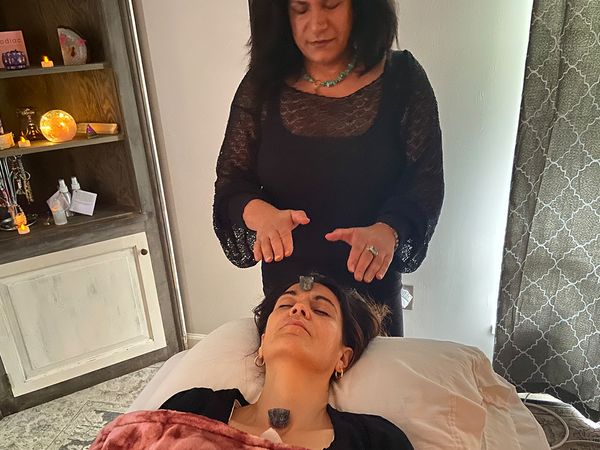 Woman performing reiki massage on client Woman performing reiki massage on client