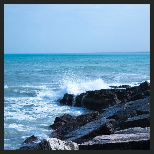 waves from the ocean crash against rocks