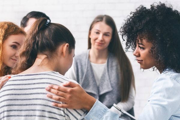 group of women comforting a girl