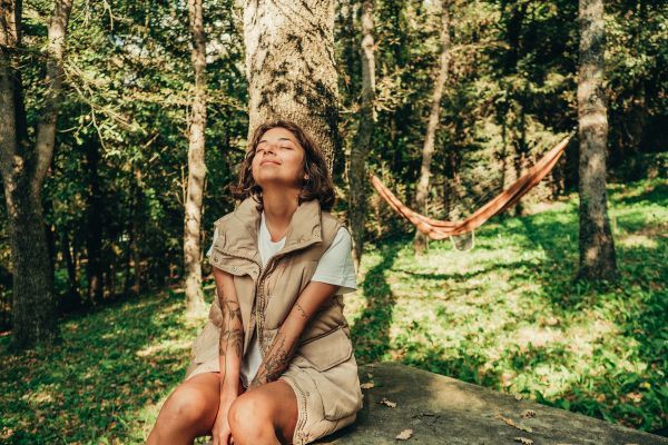 woman basking in the sun in a forest