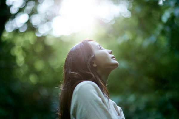 woman looking up in a forest