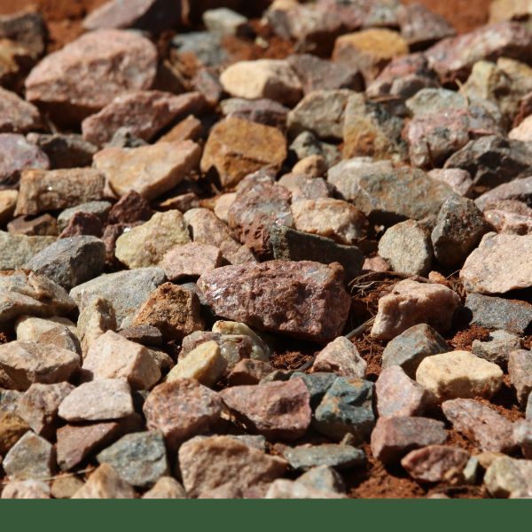 Close-up of various rocks on reddish dirt surface