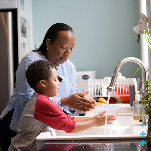 mature woman with young boy at kitchen sink