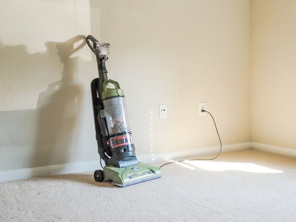 Vacuum cleaner on a clean floor plugged into a wall