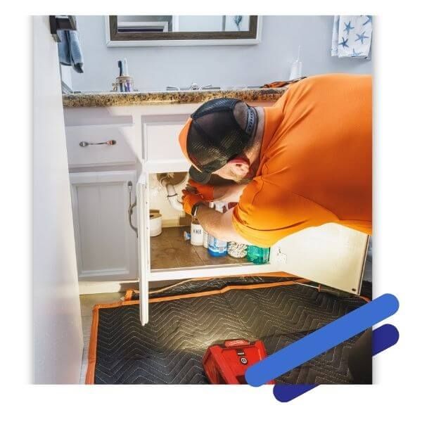 plumber working under sink