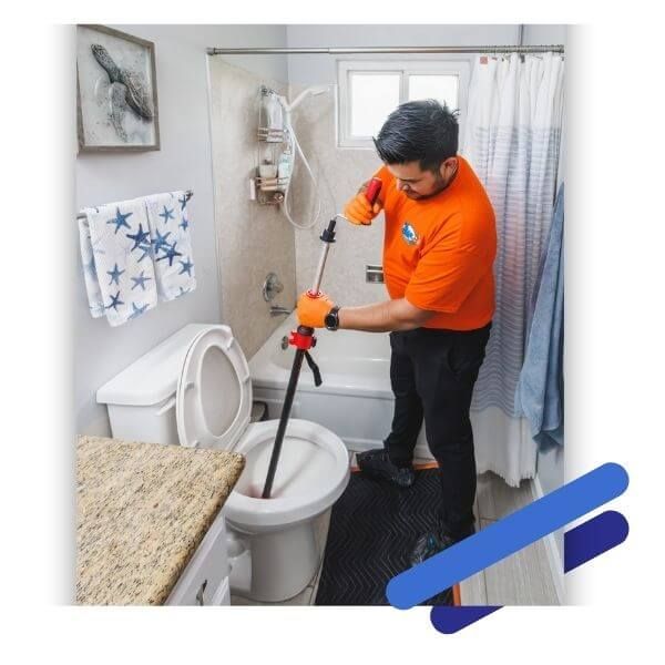 plumber unclogging toilet