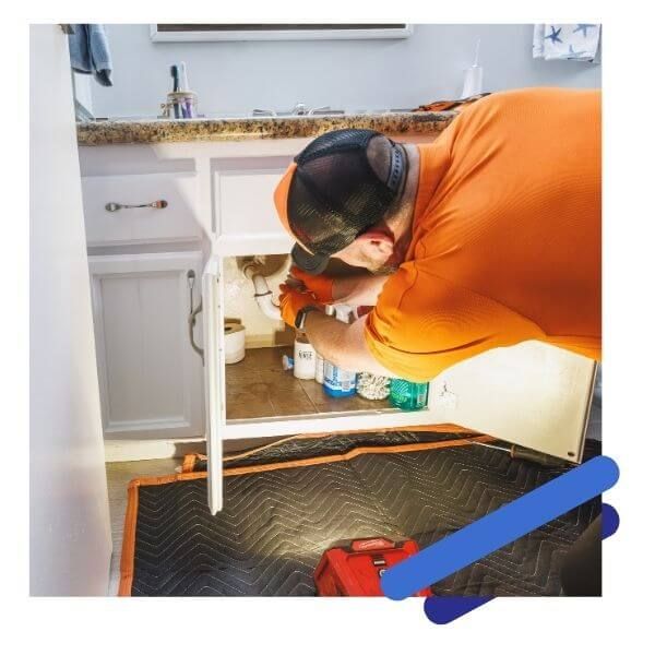 plumber working under sink