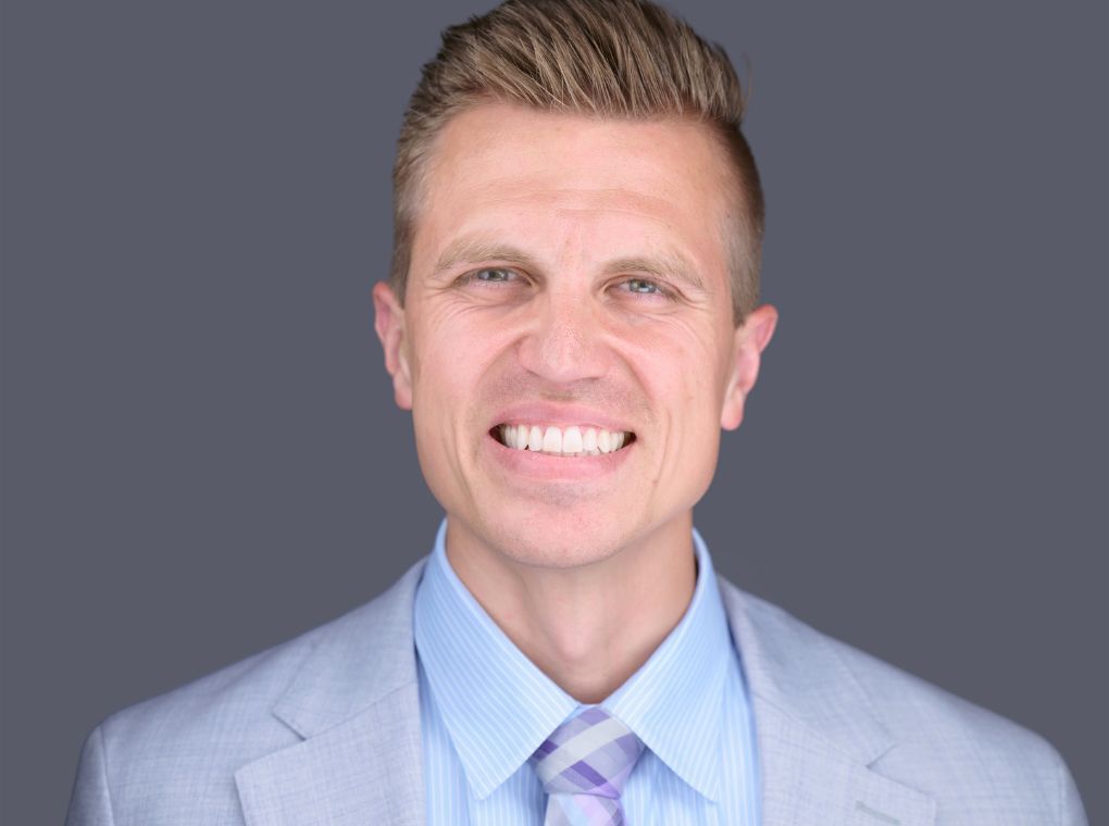 Dr. Mason in a suit smiling at the camera