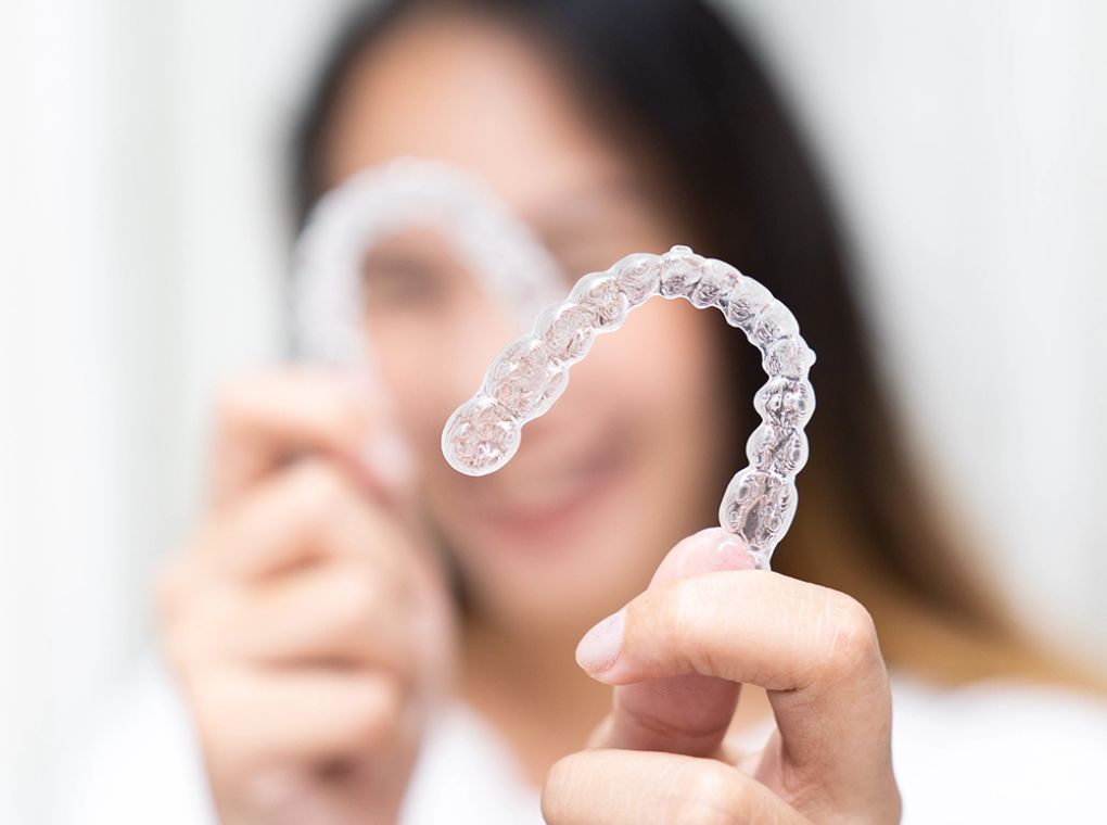 a woman holding her Invisalign to the camera
