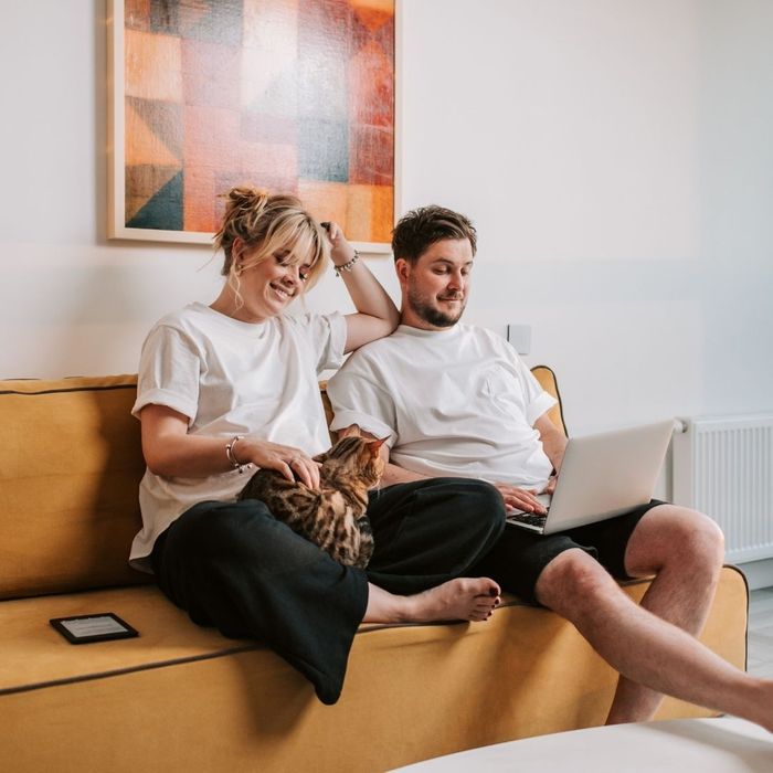 couple on the couch with their cat couple on the couch with their cat