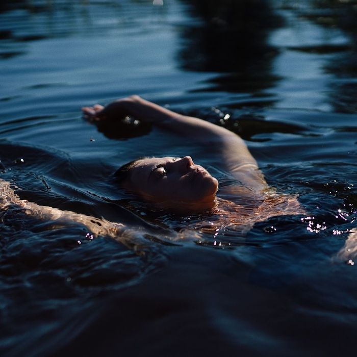 A person swimming laps in the heated saltwater pool, emphasizing active recovery.