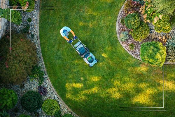 Landscaper mowing grass.