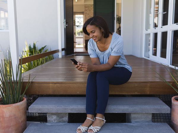 woman sitting on porch looking at mobile home insurance policies