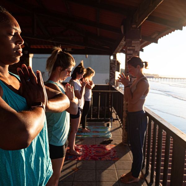 women doing yoga on a pier