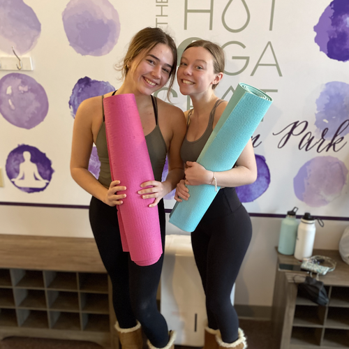 to women holding yoga mats