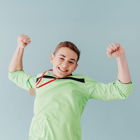 teenage boy smiling with medal
