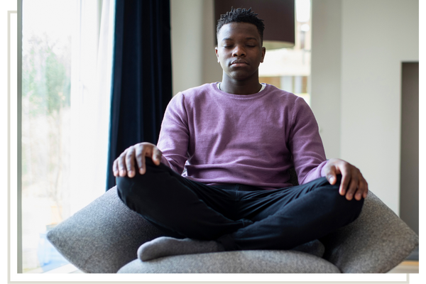 calm teen sitting cross-legged on chair