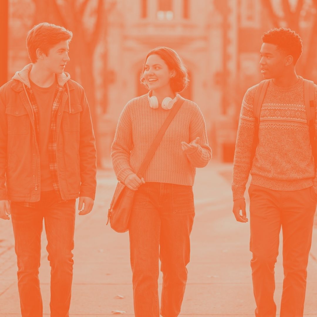 Three teenagers walking together on a sunny high school or college campus with a warm orange color overlay.