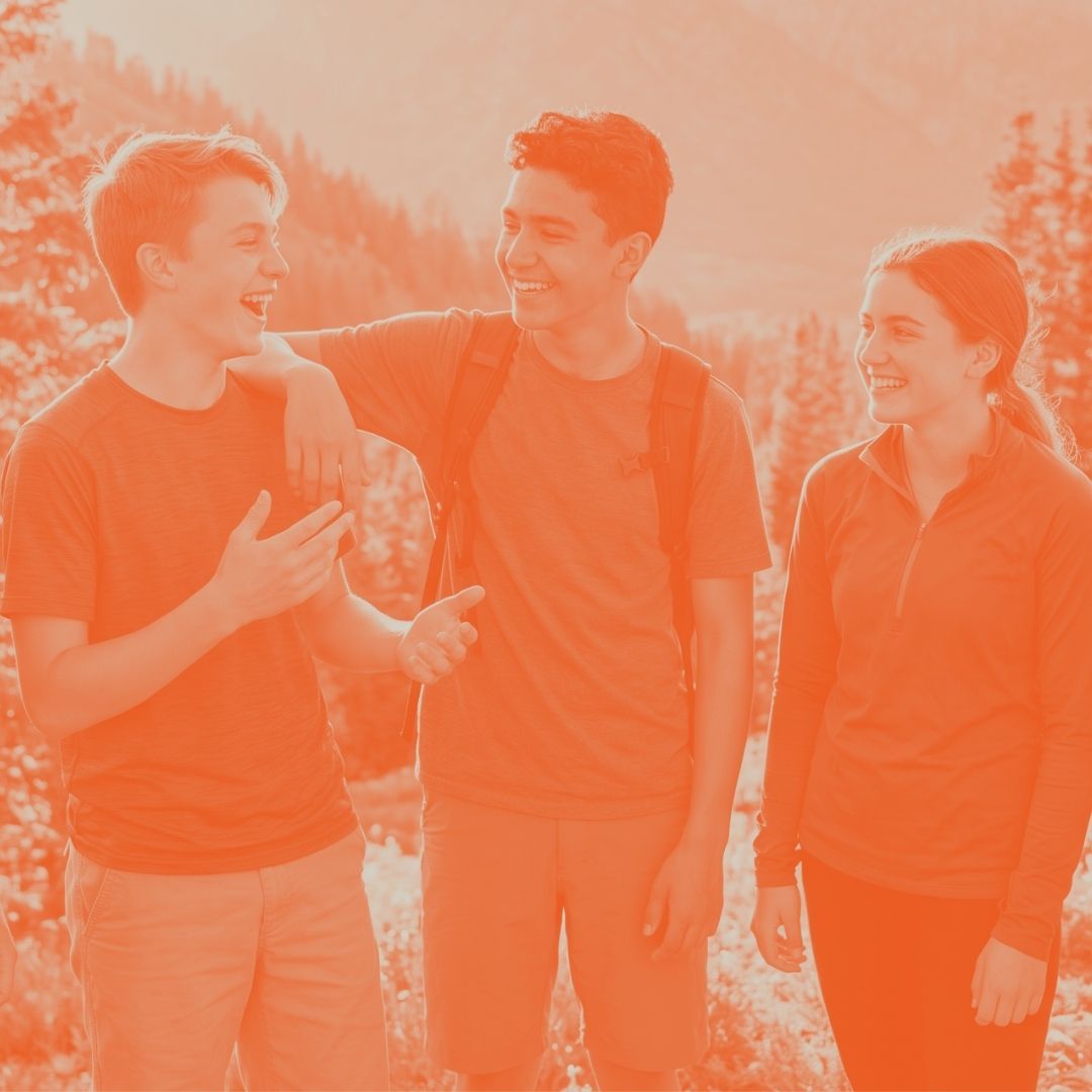 A group of happy teenagers laughing and talking together outdoors in a mountain setting. The image features a bright orange filter and shows the teens in athletic and outdoor clothing during a group activity.