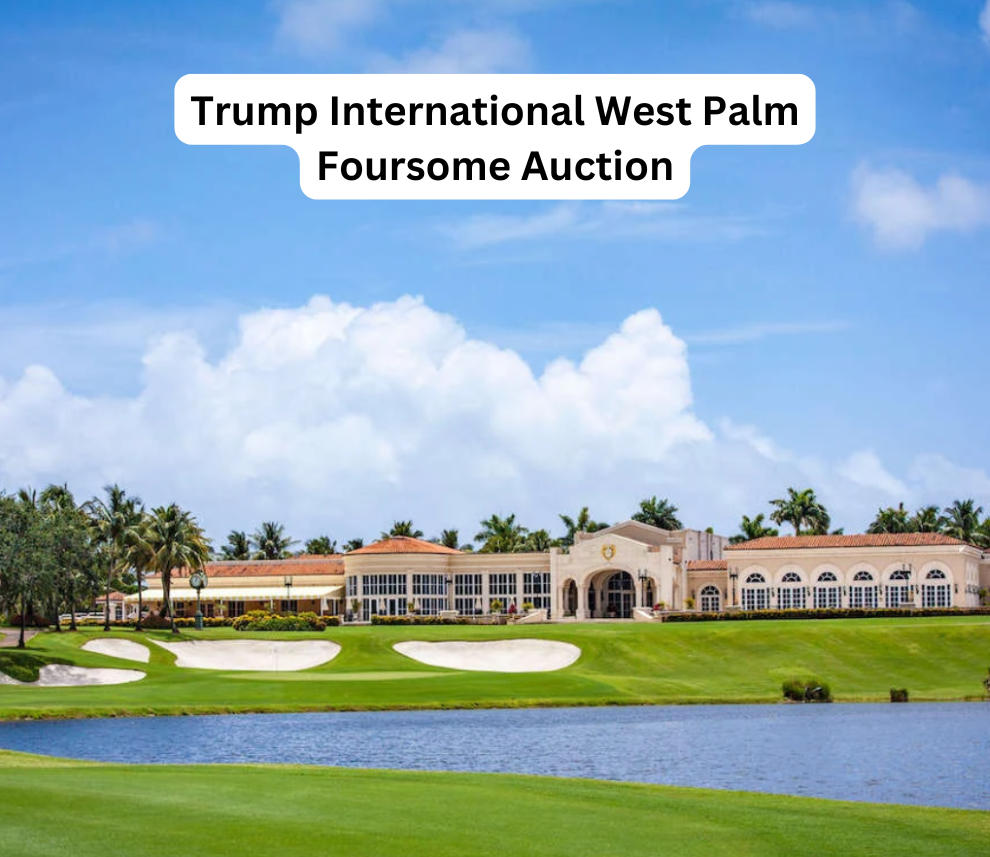 A scenic view of the Trump International Golf Club in West Palm Beach on a bright, sunny day with fluffy white clouds. The foreground features a vibrant green golf course fairway and a calm blue water hazard. In the background sits a sprawling, elegant, Mediterranean-style clubhouse surrounded by lush palm trees. Centered at the top of the image is a white text box with bold black text that reads "Trump International West Palm Foursome Auction". Trump International West Palm Foursome Auction Golf Course View