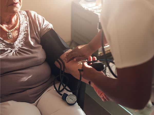 mature woman having blood pressure checked by a nurse