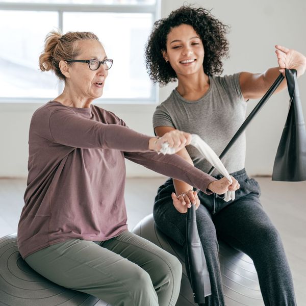 A young woman doing an exercise class with a senior-aged woman