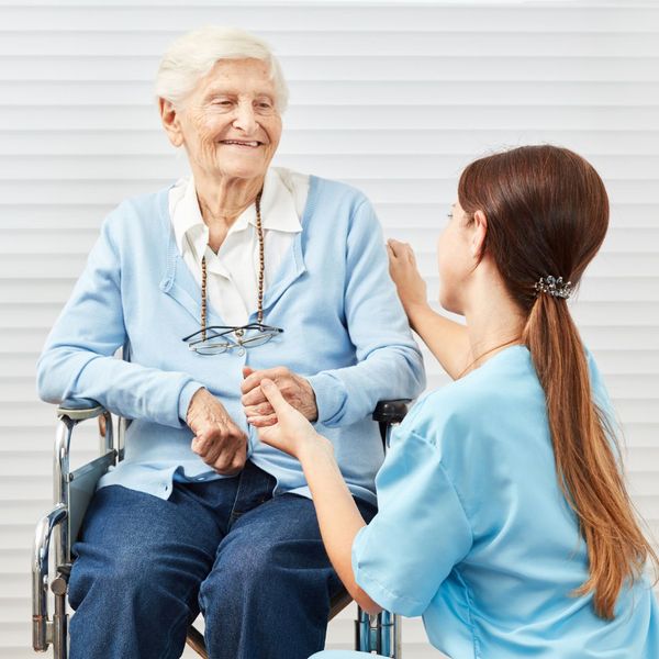 A senior woman speaking with her caregiver