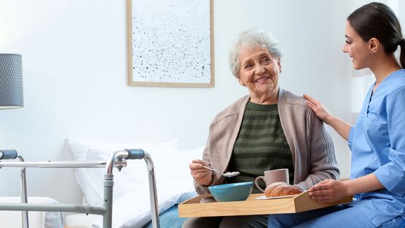 caregiver and senior talking over breakfast