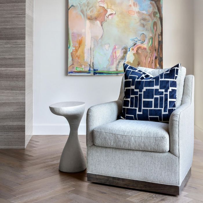 grey chair with a blue patterned pillow on it