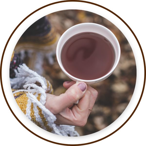 holding teacup, arm wrapped in blanket