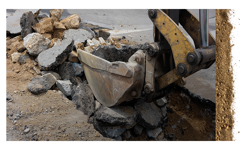 backhoe tearing up concrete