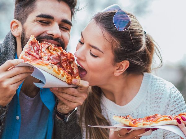 Image of a happy couple eating pizza