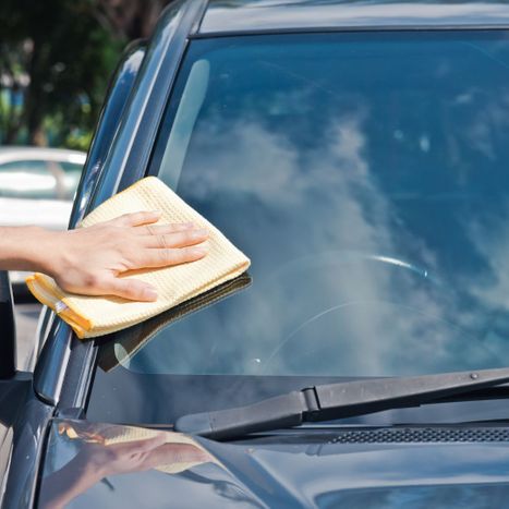 a hand wipes a windshield clean